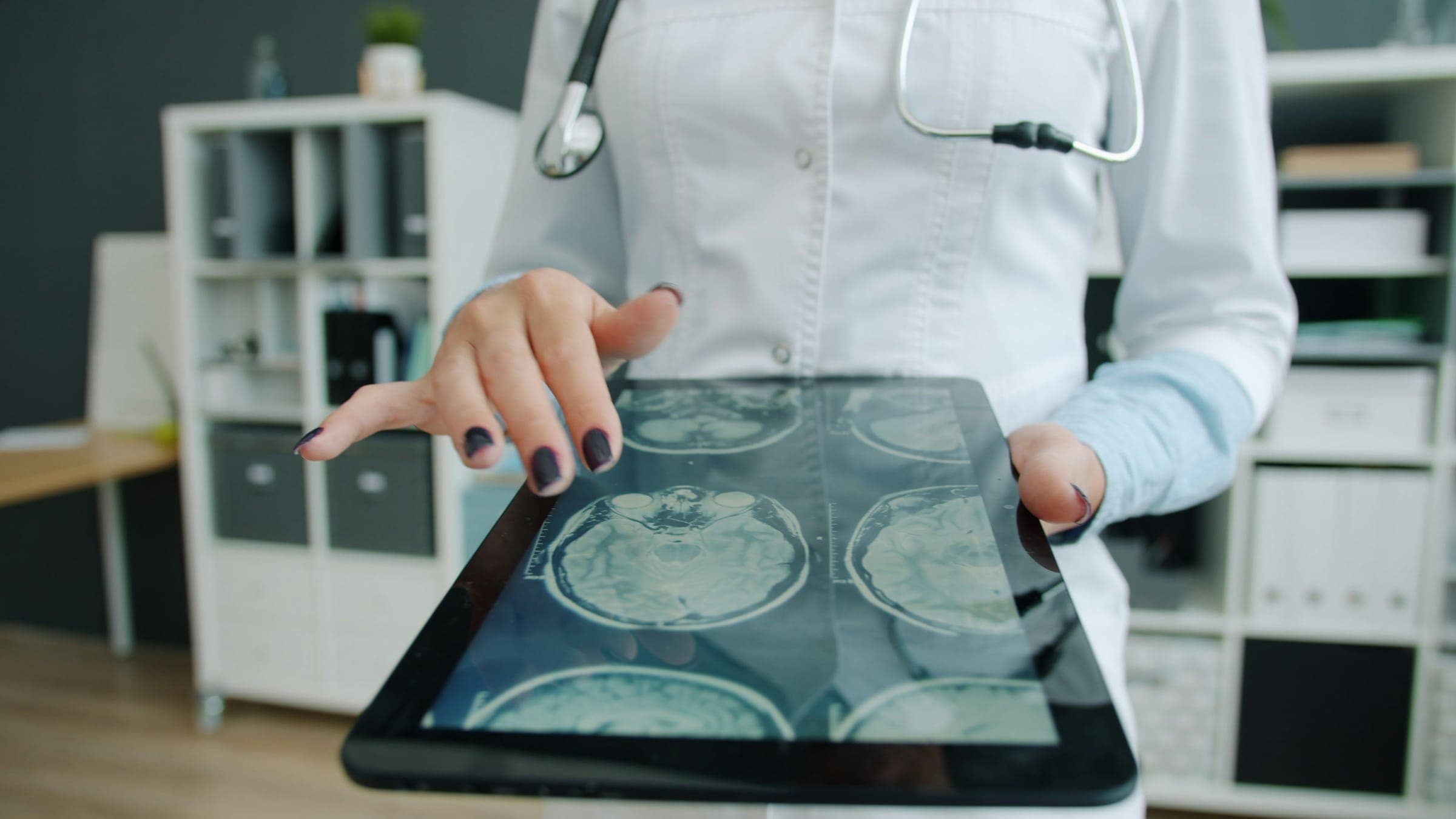 Une médecin consultant des IRM cérébrales sur une tablette